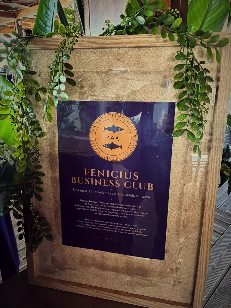 Cartel enmarcado del Fenicius Business Club decorado con hiedra